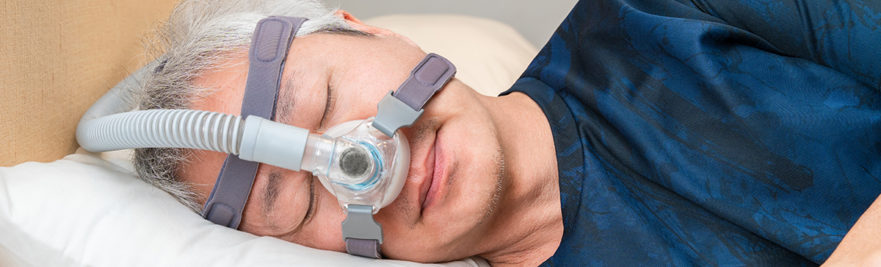 man sleeping with CPAP - sleep apnea