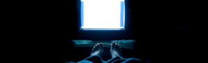 Television lighted in a dark bedroom