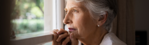 Elderly woman staring out the window.