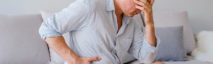 Older man holding his stomach in pain.