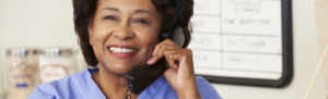 Smiling healthcare receptionist on the telephone.
