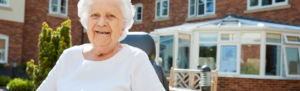 Senior resident sitting in chair outside of retirement home.