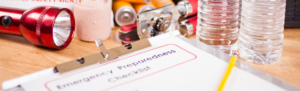 Emergency Preparedness Checklist surrounded by emergency supplies.