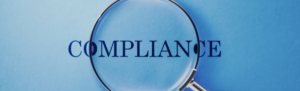 The word compliance with a magnify glass over top of it.