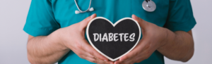 Healthcare worker holds heart sign that states diabetes.