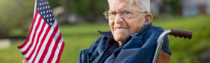 Image of an elderly American veteran holding a small American flag.