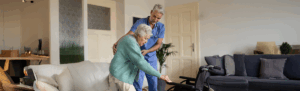 Caregiver helping elderly woman in assisted living