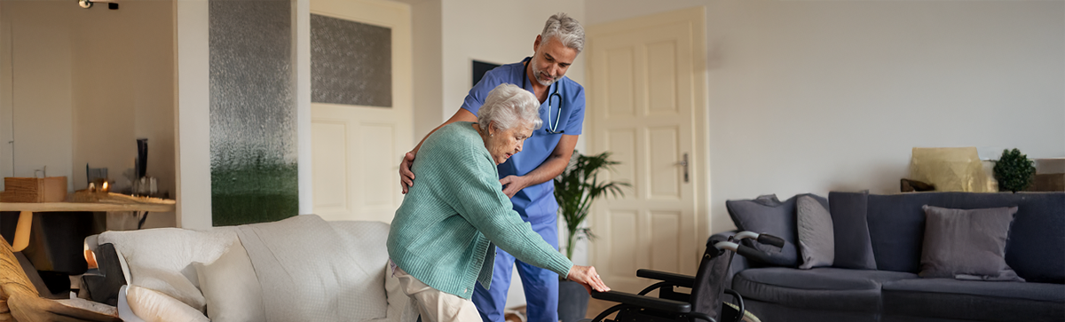 Caregiver helping elderly woman in assisted living